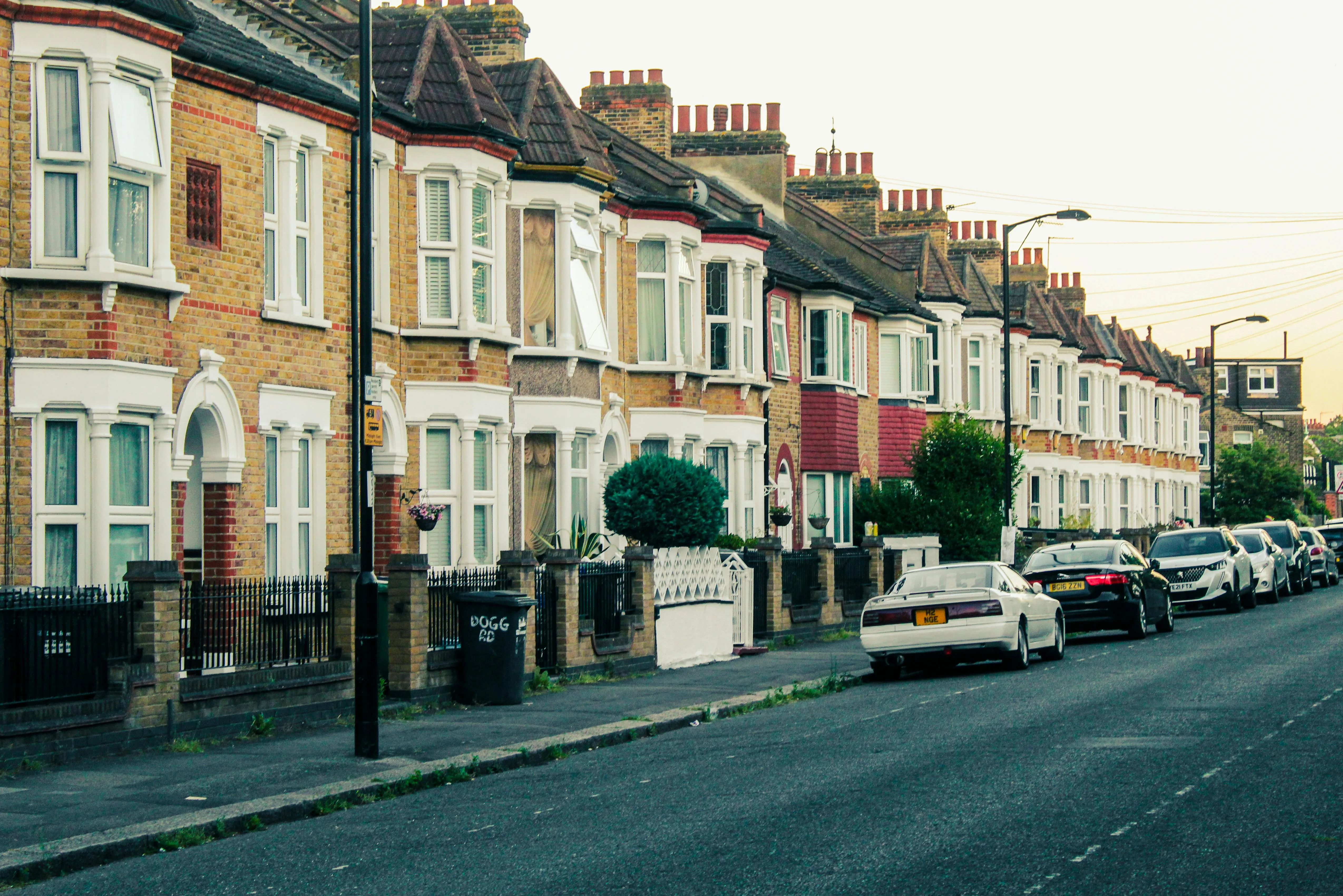 A painted-brick terraced UK home with a red front door — period terraced stock the kind we retrofit air-source heat pumps into across the wider Leicester area.